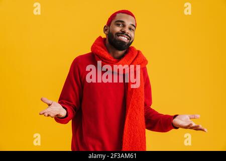 Joyful african american guy smiling and holding copyspace isolated over yellow background Stock Photo