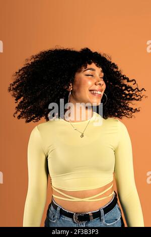 Stock photo of beautiful african woman moving her curly hair in studio shot.