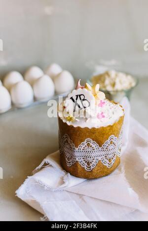 Easter cake on a background of chicken eggs and flour. Cooking sweets for Easter. Sweet cake recipe. Stock Photo