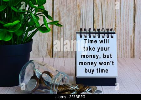 Motivational quote on paper stand and blurred glass jars with multicurrency coins Stock Photo