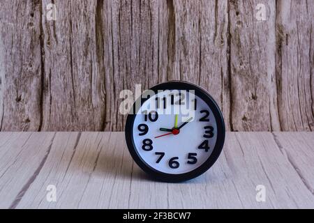 Black alarm clock on wooden table, space for text Stock Photo