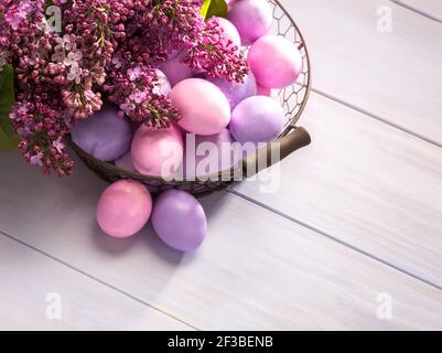 Multicolor Easter eggs and   flowers of Lilac  on  wooden table. Top view. Stock Photo