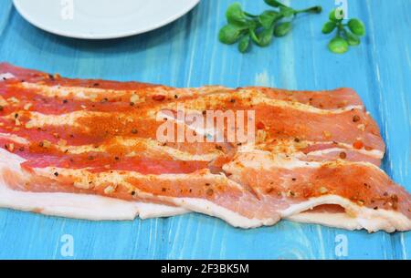 Raw bacon on a wooden background. Fresh pork meat with herbs and spices Stock Photo