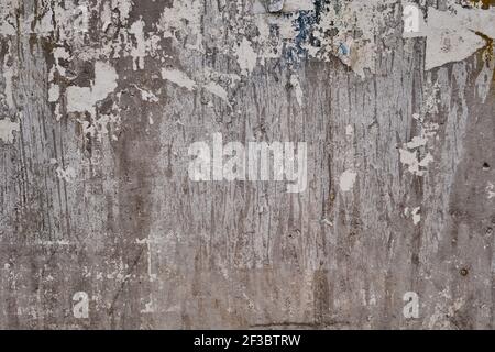 Old bulleting board wall with rests of worn peeled advertising posters, grunge background or texture Stock Photo
