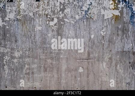 Old bulleting board wall with rests of worn peeled advertising posters, grunge background or texture Stock Photo