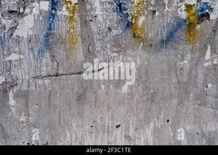 Old bulleting board wall with rests of worn peeled advertising posters, grunge background or texture Stock Photo