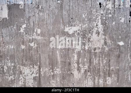 Old bulleting board wall with rests of worn peeled advertising posters, grunge background or texture Stock Photo