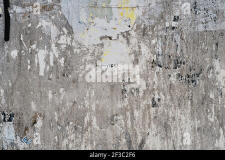 Old bulleting board wall with rests of worn peeled advertising posters, grunge background or texture Stock Photo