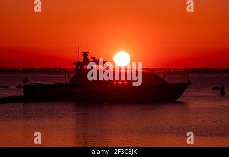 09 March 2021, Mecklenburg-Western Pomerania, Schaprode: A water taxi sails towards Hiddensee at sunset. The ferry route connects the Baltic Sea islands of Rügen and Hiddensee. Photo: Jens Büttner/dpa-Zentralbild/ZB Stock Photo