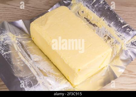 Pack of salted butter with unwrapped paper Stock Photo