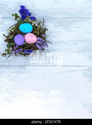 A nest with Easter eggs. Gray-blue background. Three Easter eggs in the nest. Stock Photo