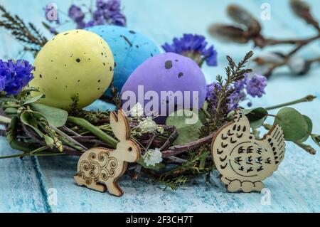 Happy Easter. A nest with Easter eggs. Willow twigs. Holy Easter. Blue background. Easter bunny and chicken. Stock Photo