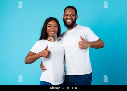 Happyafro couple gesturing thumbs up and smiling Stock Photo