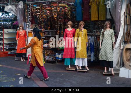 10.03.2021, Singapore, Republic of Singapore, Asia - Woman walks past a shop in Little India that displays mannequins in traditional Indian dresses. Stock Photo