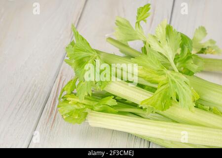 Bunch of fresh celery stalk with leaves on a wooden background Stock Photo