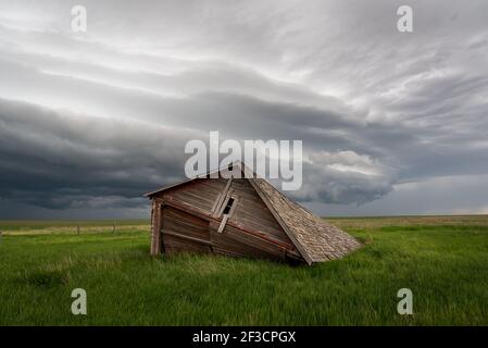 Dramatic storm clouds over a green picturesque field. Landscape the gathering storm. Stock Photo