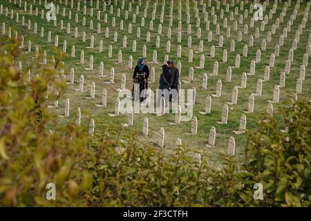 Halabja, Iraq. 16th Mar, 2021. A family visits the grave of their lost ones at Halabja Cemetery on the 33rd anniversary of Halabja chemical attack, which killed nearly 5000 people and injured about 10000, most of them were civilians. Credit: Ismael Adnan/dpa/Alamy Live News Stock Photo