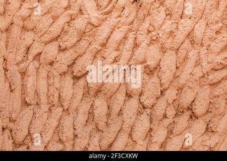 Photography of texture and background of a facade arranged with cement and painted salmon pink, in a house in Ambel, a small town in the Campo de Borj Stock Photo