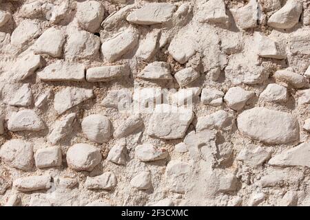 Photography of texture and background of an irregular facade built with stones and painted white, in a house in Ambel, a small town in the Campo de Bo Stock Photo
