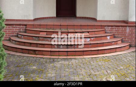 Damaged house staircase or stairs with broken tiles over concrete steps Stock Photo