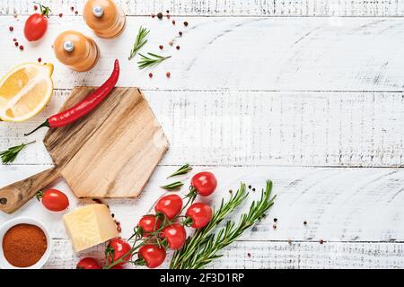 Cooking Background with spices: pepper, rosemary, paprika, lemon, onion, asparagus, olive oil, tomato, parmesan cheese, cooking board and napkin on ol Stock Photo