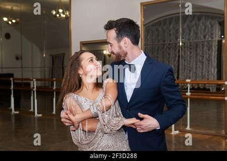man and woman dance, looking at each other, in large empty ballroom Stock Photo