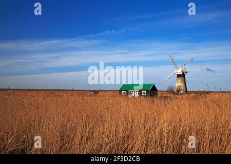 A view of St Benet's Level Drainage Mill and a riverside chalet on Horning Marshes by the River Thurne viewed from Thurne, Norfolk, England, UK. Stock Photo