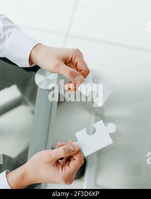 pieces of the puzzle are in the hands of a businessman. Stock Photo