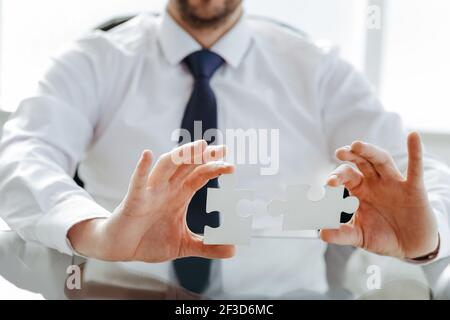 image of a happy businessman putting together the puzzle pieces. Stock Photo