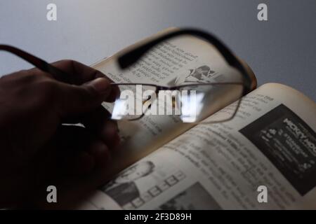 The reader is tired; he has kept his spectacles on the book. Stock Photo