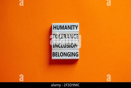 Humanity, tolerance, inclusion, belonging symbol. Wooden blocks with words humanity, tolerance, inclusion, belonging on beautiful orange background. T Stock Photo