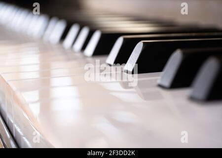 Close up of the keyboard of a piano with shiny white and black keys Stock Photo