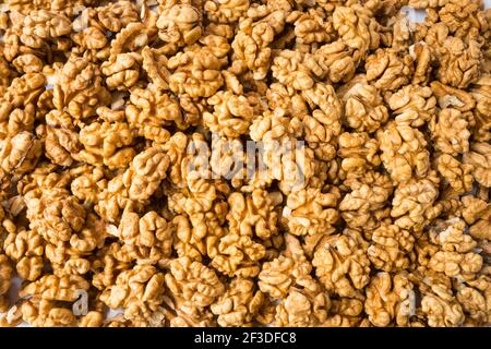 Big kernels walnuts situated arbitrarily. Closeup of big shelled walnuts. Walnut background, scattered pile of walnuts. Kernels walnuts. Top view. Veg Stock Photo