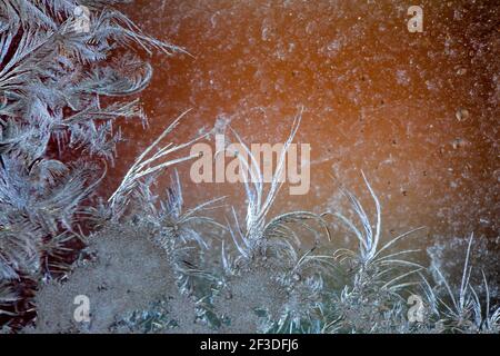 Jack Frost etchings on the window, with a colourful background. Stock Photo