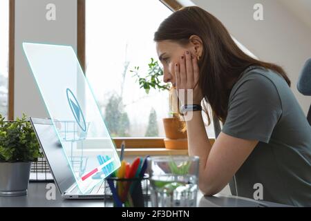 Women watching a video on a laptop at home office. New normal office working concept. Stock Photo