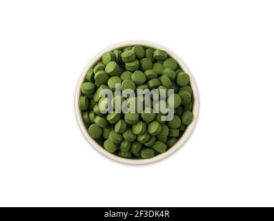 spirulina/chlorella tablets isolated on white background. Organic spirulina and chlorella pills in a wooden bowl isolated on white. Green spirulina ch Stock Photo