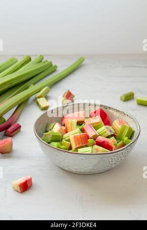 Chopped rhubarb stalks bowl on the kitchen table Stock Photo