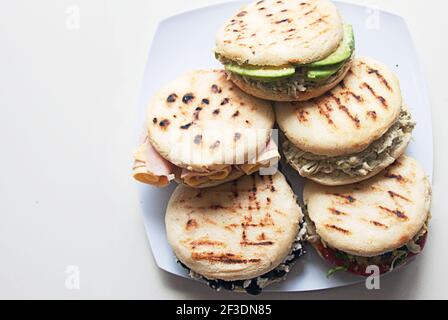 Arepas are is a type of food made of ground maize dough or cooked flour prominent in the cuisine of Colombia and Venezuela. Here Homemade Venezuelan Arepas Close up Background. Arepas Venezolanas Authentic Stock Photo