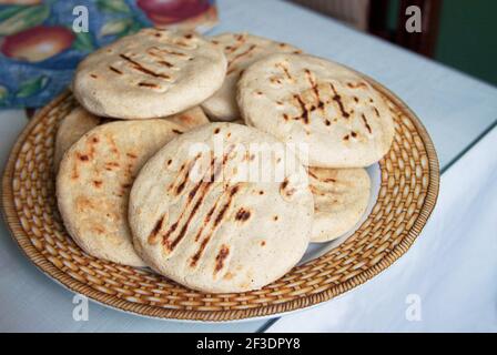 Arepas are is a type of food made of ground maize dough or cooked flour prominent in the cuisine of Colombia and Venezuela. Here Homemade Venezuelan Arepas Close up Background. Arepas Venezolanas Authentic Stock Photo