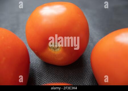 Close-up of fresh tomatoes on a dark blue table Stock Photo