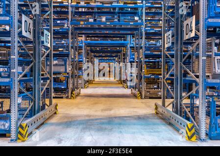 Forklift cross bridge aisle in racking system in modern distribution center warehouse. Transport and logistics concept. Stock Photo