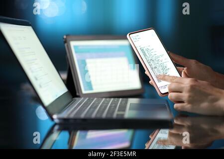 Close up of a woman hands using multiple devices at home in the night Stock Photo