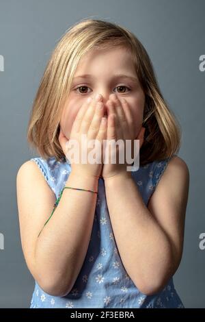 5 year old caucasian girl with hands covering her face. Stock Photo