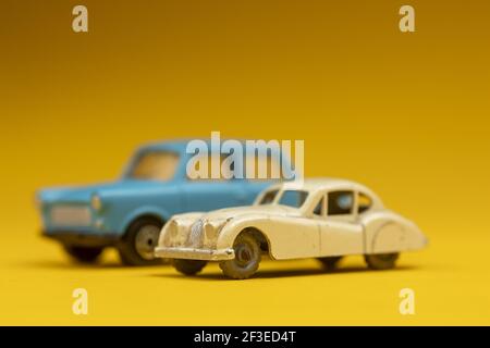 Couple of oldtimer vintage miniature cars on clean colorful background. Stock Photo