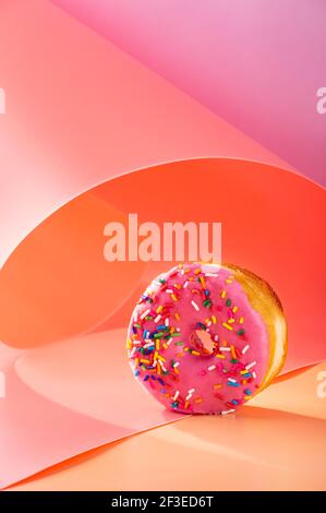 Mix of donuts on pink and caramel swirled background with copy space Stock Photo