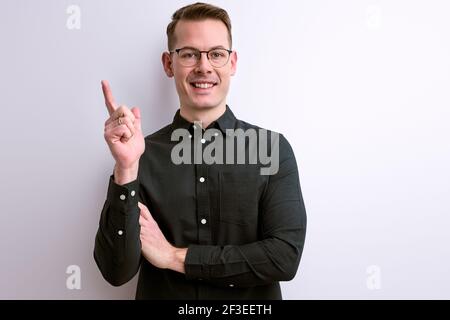 optimistic smart intelligent guy raising finger up copy space for advertisement. isolated white background Stock Photo