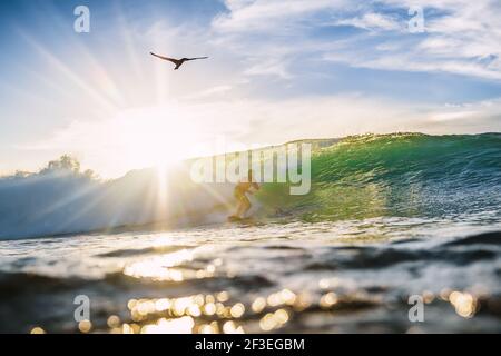 December 30, 2020. Bali, Indonesia. Surfer ride on surfboard at ocean wave. Professional surfing in ocean at waves Stock Photo