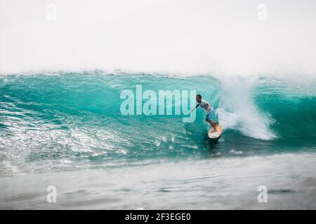 December 30, 2020. Bali, Indonesia. Surfer ride on surfboard at ocean wave. Professional surfing in ocean at waves Stock Photo