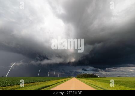 Dramatic storm clouds over a dirt road and farm field near Northwood, Minnesota Stock Photo