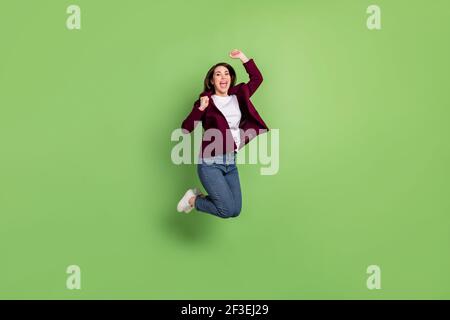 Full size profile photo of hooray brown hairdo lady jump wear cardigan jeans sneakers isolated on green background Stock Photo